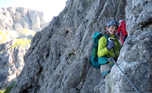 Dame die lachend in de camera kijkt, met een karabiner in haar handen