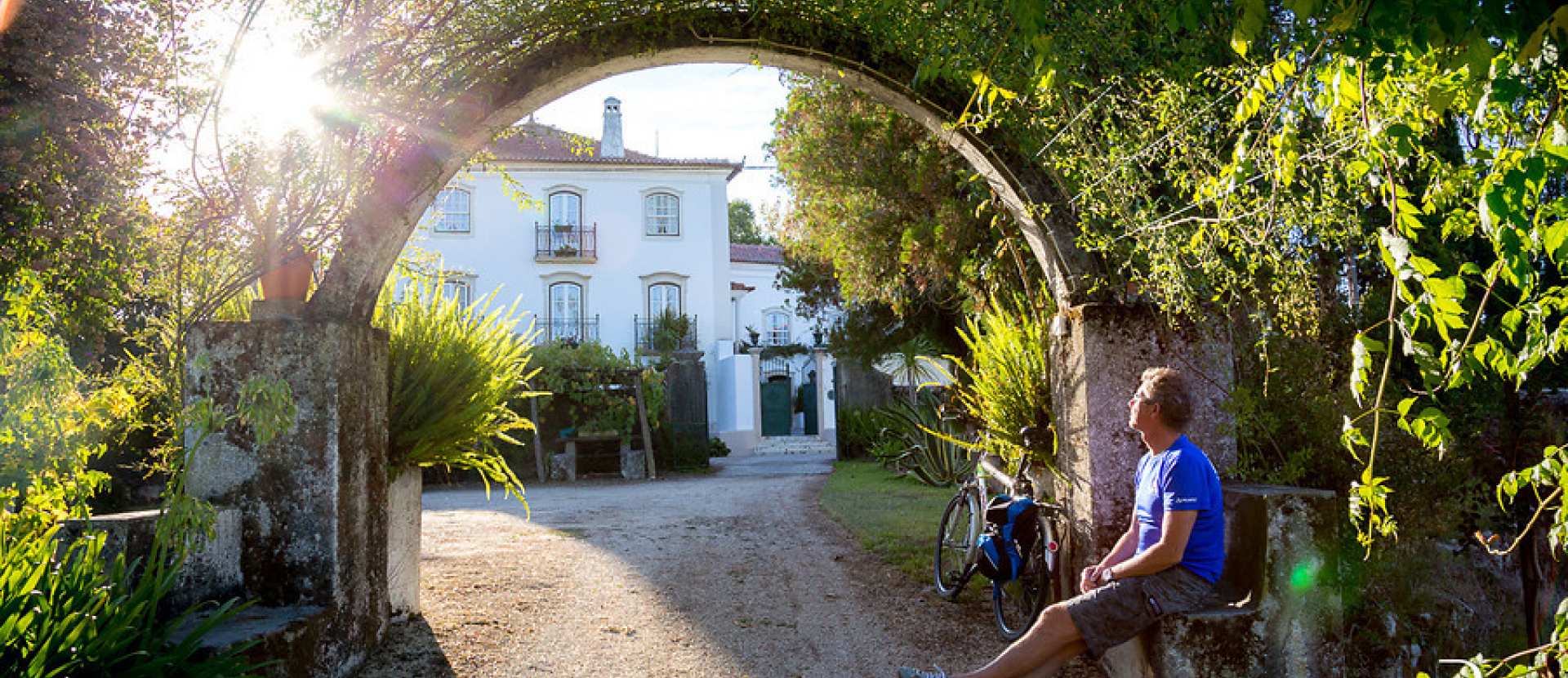 Coïmbra, man zit op een randje met zijn fiets ernaast