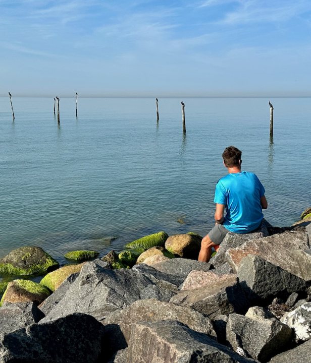 zit op stenen naast water