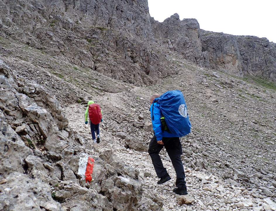 Twee wandelaars in de bergen met op de voorgrond het rood-wit-teken