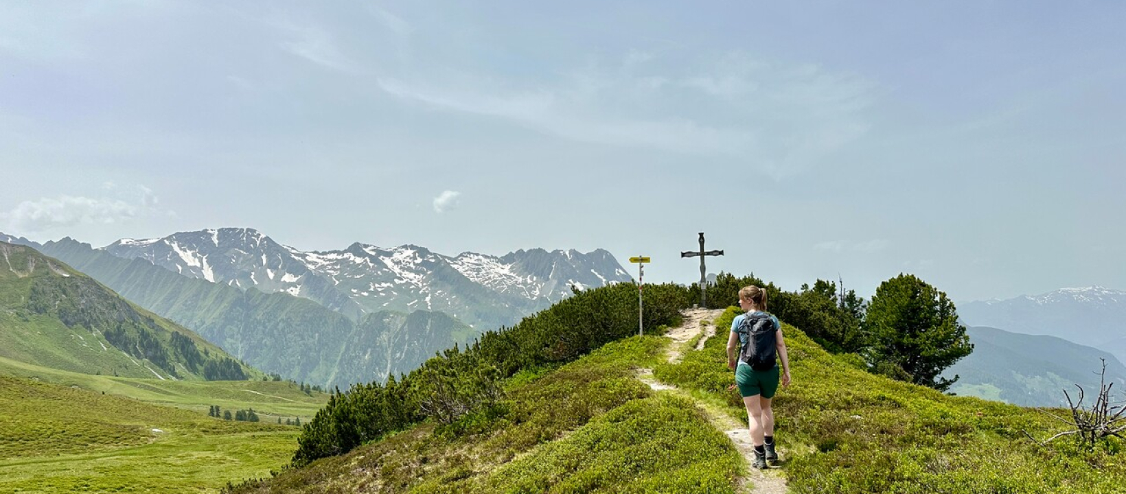 Wandelaar die naar een topkruis toeloopt