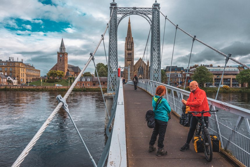 Fietser op de brug van Inverness, Schotland