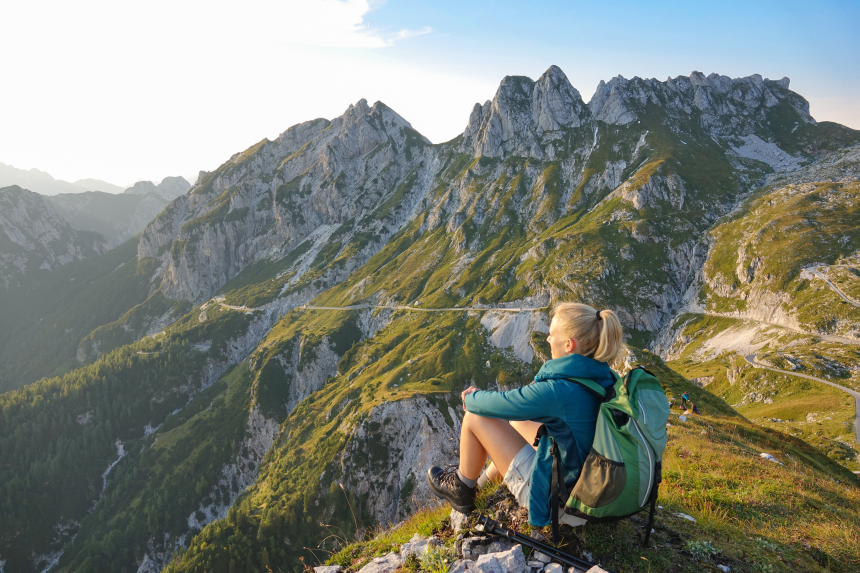 Zittende dame die uitkijkt over een berglandschap